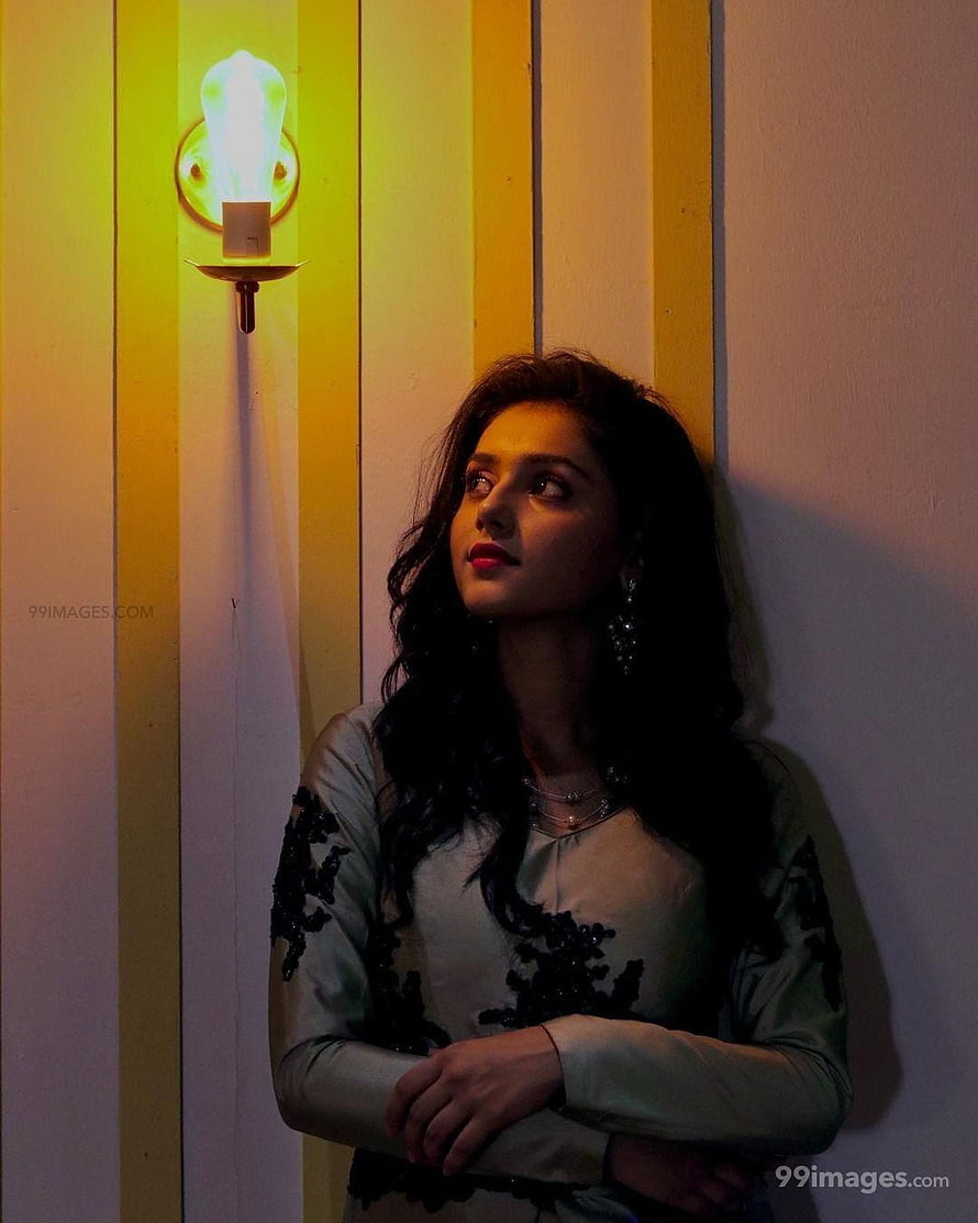Mallika Singh in moody portrait with warm wall sconce lighting and elegant embroidered attire HD phone wallpaper