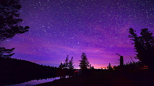 Purple Starry Night Sky Over Lake With Silhouetted Trees And Campervan HD wallpaper