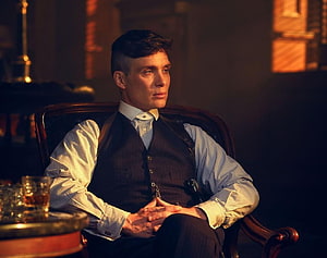Tommy Shelby Seated in a Dimly Lit Room Wearing a Vintage Waistcoat and Shirt HD wallpaper