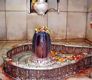 Sacred Shiva Lingam with Silver Abhishekam Vessel and Flower Offerings HD wallpaper