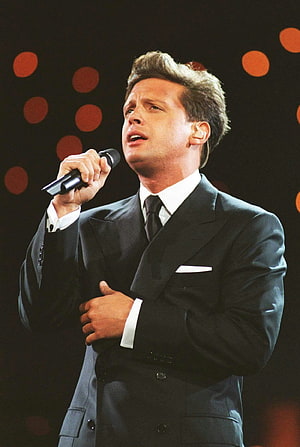 Luis Miguel performing on stage in a black suit holding a microphone HD phone wallpaper