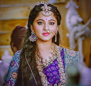 Anushka Shetty in ornate traditional Indian bridal attire with elaborate gold jewelry and headpiece HD wallpaper
