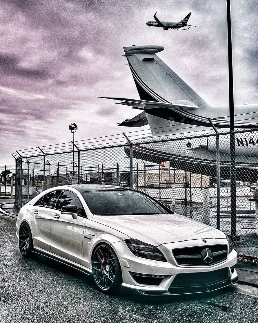 White Mercedes-Benz CLS 63 AMG parked near airport runway with airplane HD phone wallpaper