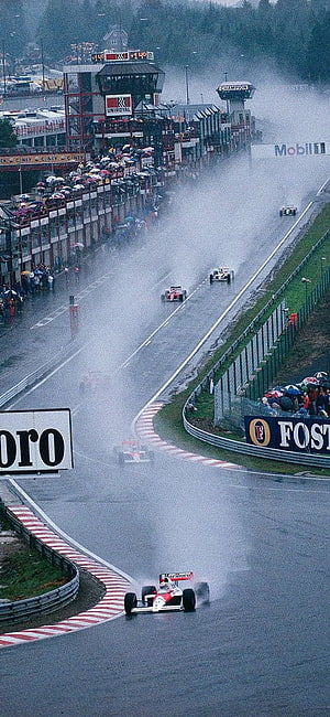 Classic Formula 1 race at Spa-Francorchamps in heavy rain with spray and spectators HD phone wallpaper