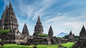 Prambanan Temple Complex with Mount Merapi in the Distance Under a Blue Sky HD wallpaper