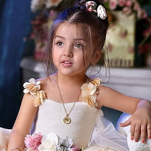Elegant Little Girl in White Floral Dress with Gold Necklace and Hair Accessories HD wallpaper