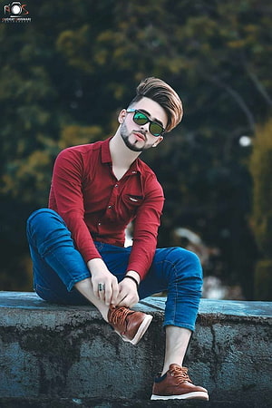 Stylish Young Man in Red Shirt and Sunglasses Sitting on Stone Wall, Cool Boy New Poses Pic graphy Poses Poses for boy, boys pose HD phone wallpaper