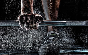 Gripping a Barbell in a Dusty Gym Environment HD wallpaper