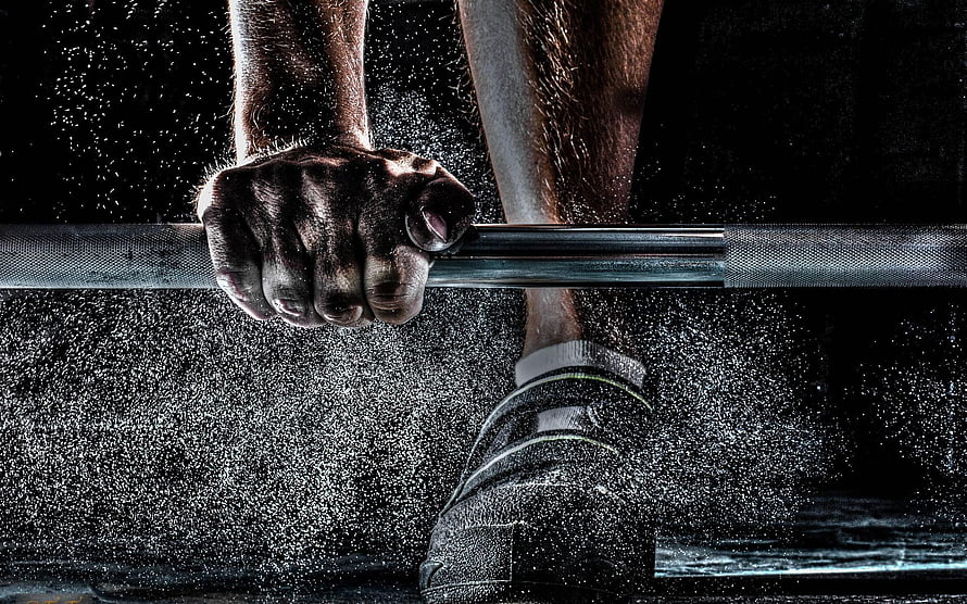 Gripping a Barbell in a Dusty Gym Environment HD wallpaper