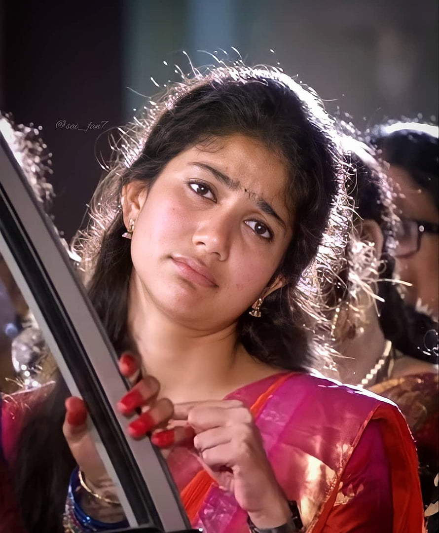 Sai Pallavi in a pink sari with a pensive expression and red nail polish HD phone wallpaper