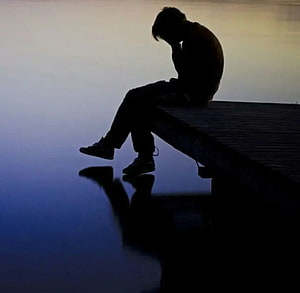 Silhouette of a Lonely Person Sitting on a Dock at Sunset HD wallpaper