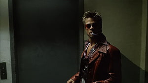 Brad Pitt as Tyler Durden in Fight Club wearing a red leather jacket and sunglasses in a dimly lit elevator HD wallpaper