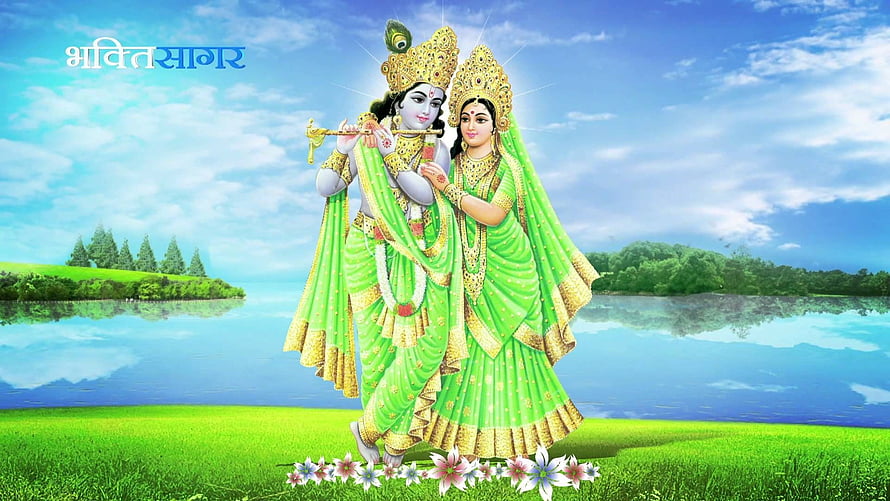 Radha Krishna standing together in green attire by a serene lake with blue sky and lush greenery HD wallpaper