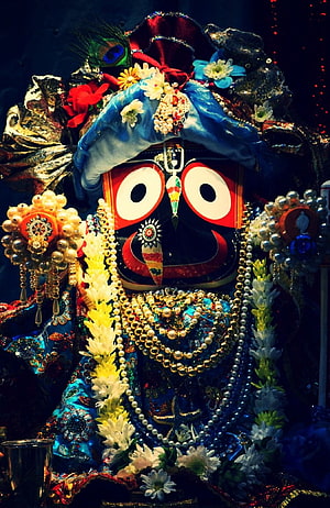 Ornate Hindu deity statue adorned with flowers, pearls, and vibrant blue garments HD phone wallpaper