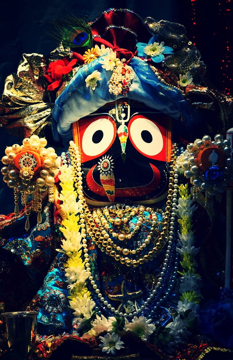 Ornate Hindu deity statue adorned with flowers, pearls, and vibrant blue garments HD phone wallpaper