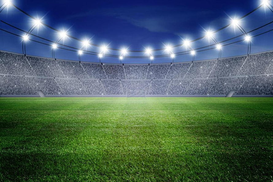Illuminated Football Stadium at Night with Full Crowd and Bright Floodlights HD wallpaper