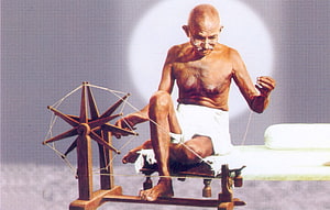 Mahatma Gandhi Sitting at a Charkha Spinning Wheel in White Dhoti HD wallpaper