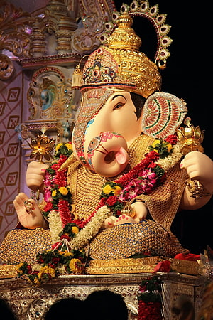 Ornate Ganesha Idol Adorned With Gold Jewelry And Floral Garlands HD phone wallpaper