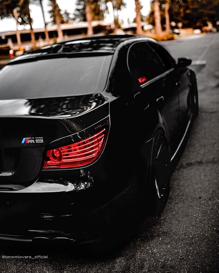 Black BMW M5 Sedan Rear View with Carbon Fiber Trunk and Red Taillights HD phone wallpaper