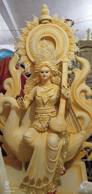 Intricate Saraswati Deity Sculpture with Veena and Golden Accents HD phone wallpaper