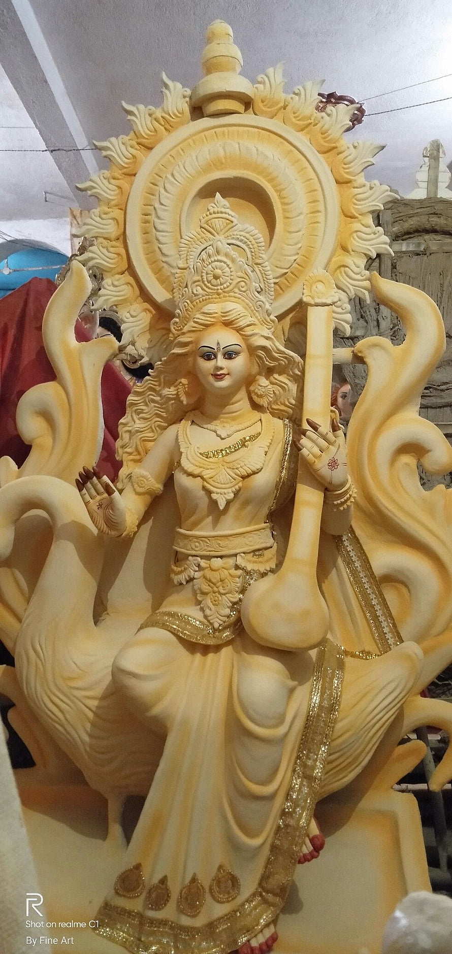 Intricate Saraswati Deity Sculpture with Veena and Golden Accents HD phone wallpaper