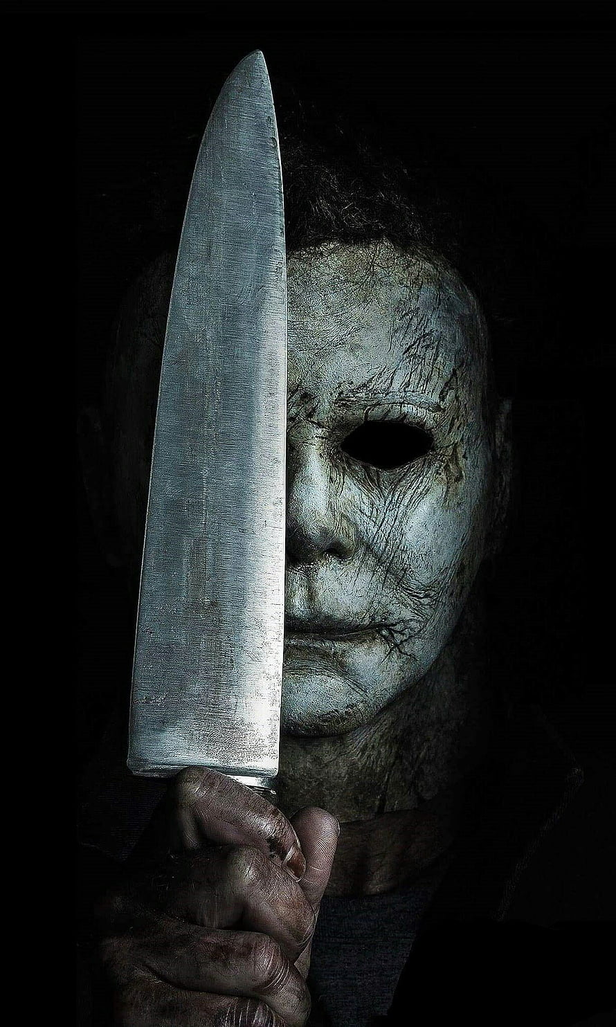 Michael Myers from Halloween Holding a Large Kitchen Knife in Dark Horror Setting HD phone wallpaper