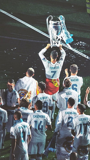 Cristiano Ronaldo lifting the Champions League trophy with Real Madrid teammates on the pitch HD phone wallpaper