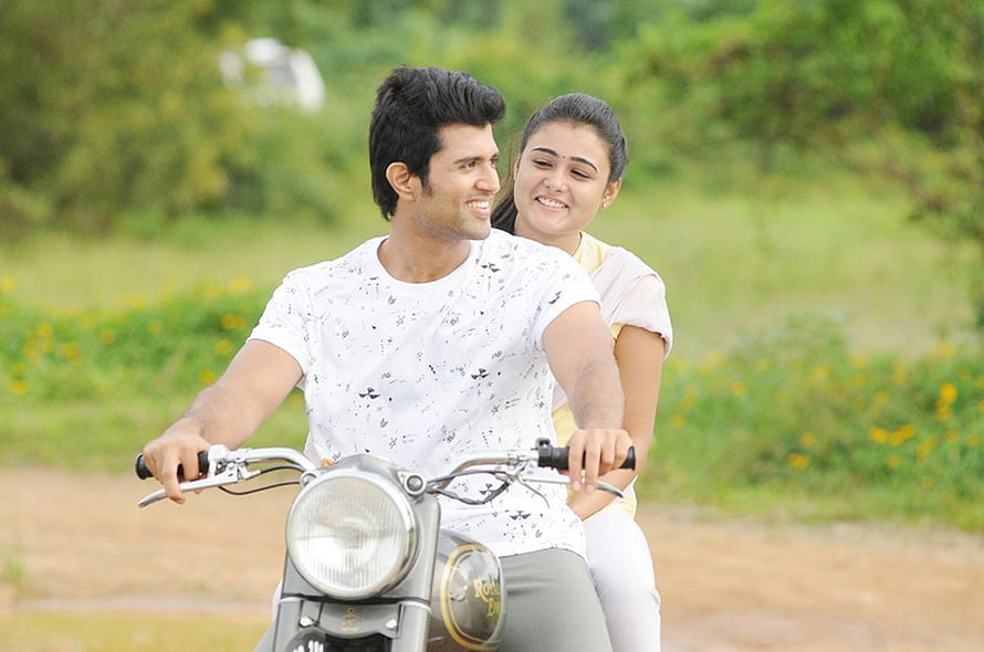 Arjun Reddy and female lead riding a motorcycle through a lush green countryside HD wallpaper