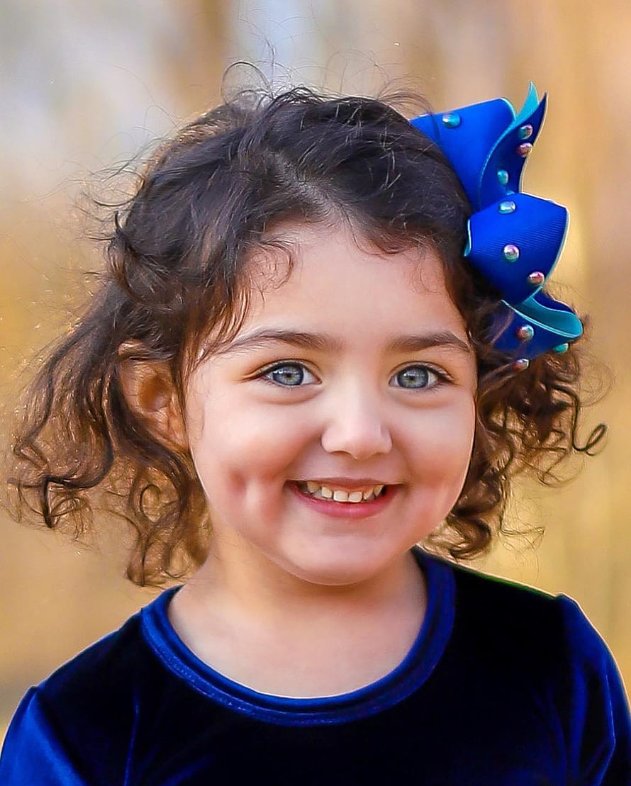 Anahita Hashemzadeh Smiling Portrait with Curly Hair and Blue Bow HD phone wallpaper