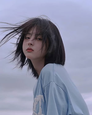 Justina Xie Aesthetic Portrait With Windblown Hair and Soft Blue Shirt HD phone wallpaper