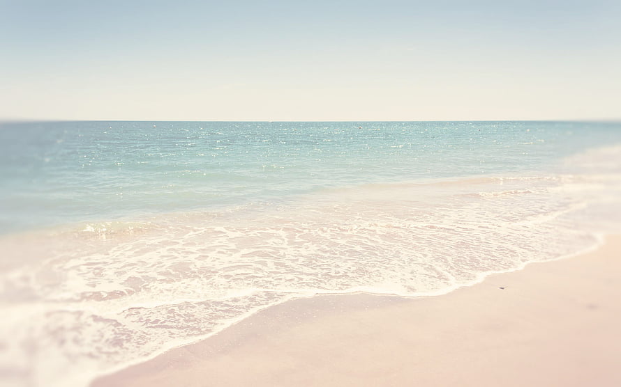 Serene Summer Beach with Gentle Waves and Soft Sand Under a Clear Sky HD wallpaper