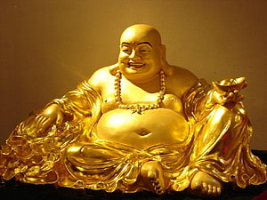 Golden Laughing Buddha Statue Holding Gold Ingot and Coins HD wallpaper