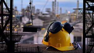 Yellow Hard Hat and Safety Goggles on Industrial Construction Site at Dusk HD wallpaper