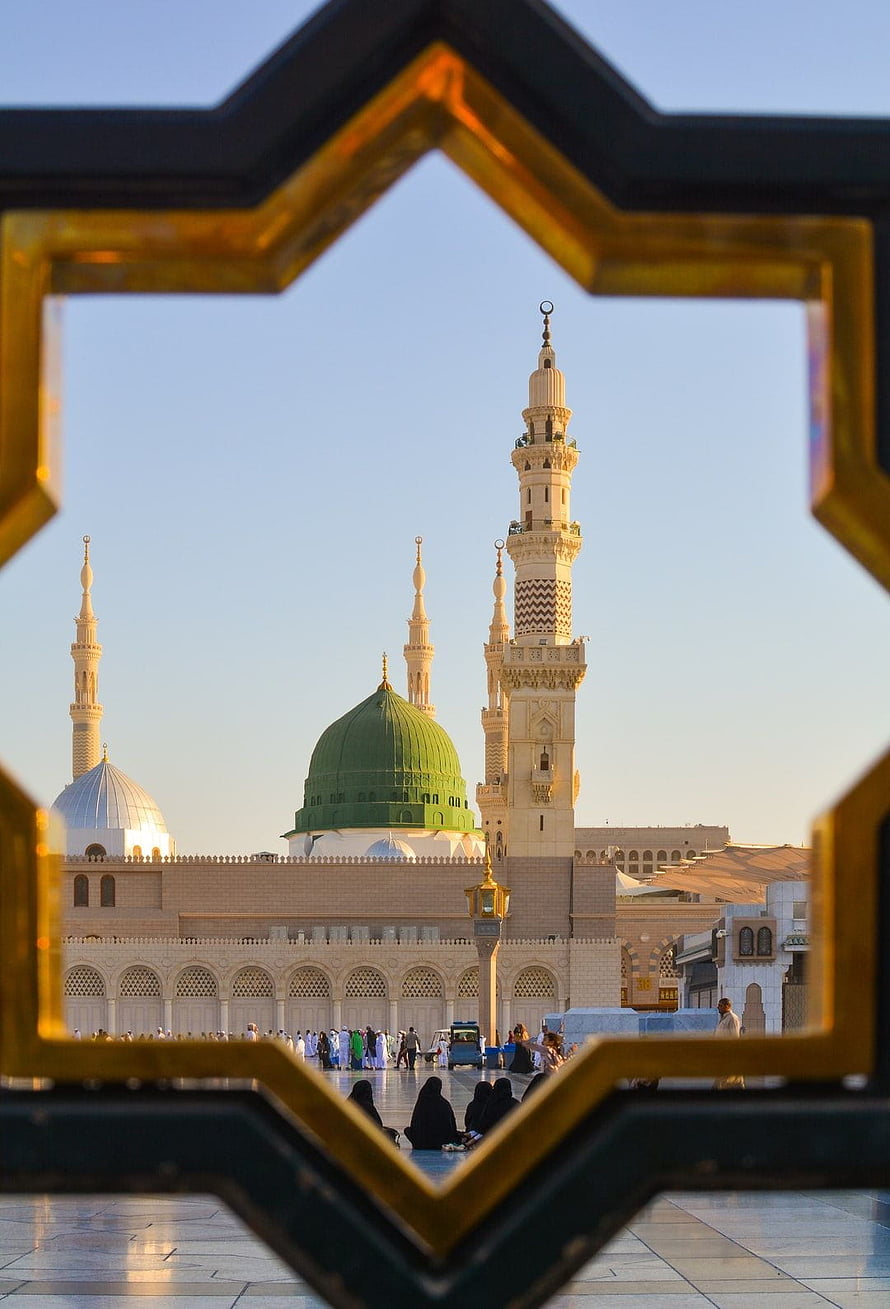 Al-Masjid an-Nabawi in Medina framed by an ornate golden Islamic geometric window HD phone wallpaper