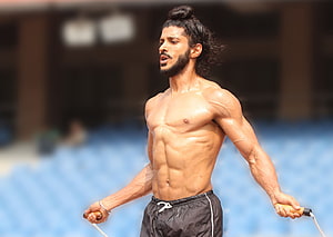 Farhan Akhtar as Milkha Singh in a shirtless jump rope training scene HD wallpaper