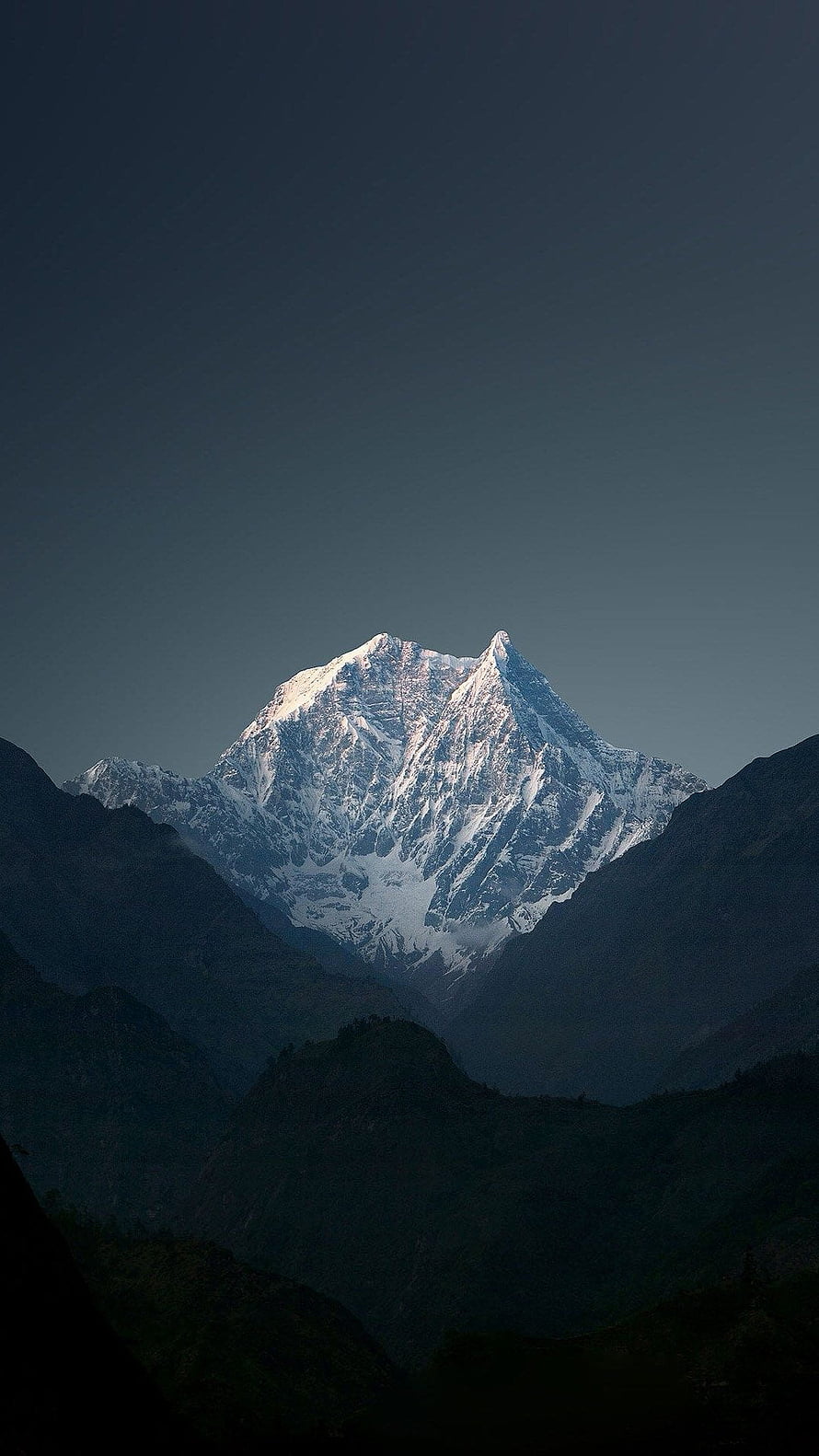 Majestic Snow-Capped Mountain Peak Rising Above Dark Forested Valleys HD phone wallpaper