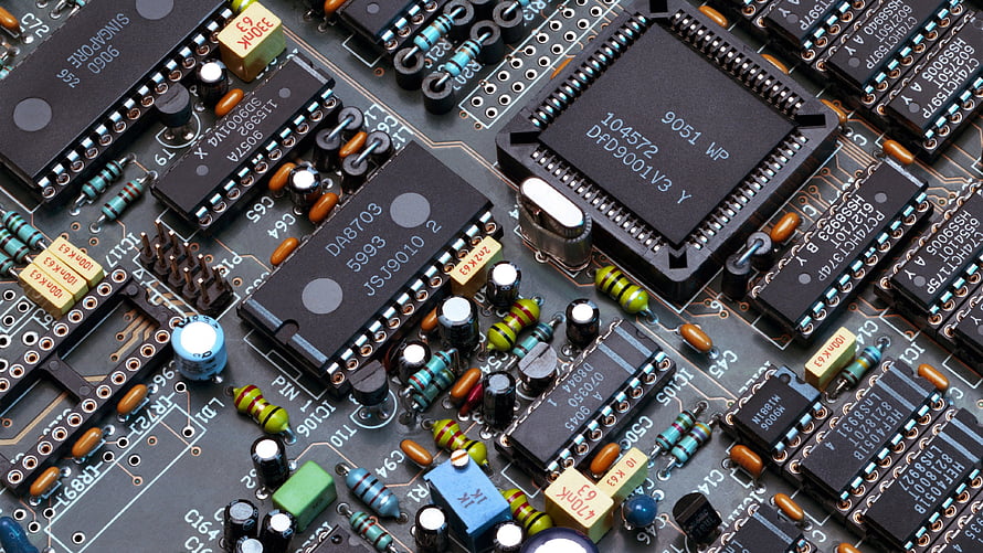 Close-up of a densely populated printed circuit board with integrated circuits and electronic components HD wallpaper