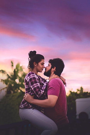 Romantic Couple Embracing at Sunset with Vibrant Pink and Purple Sky HD phone wallpaper