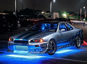 Nissan Skyline R34 GT-R with Blue Underglow and Racing Livery at Night HD wallpaper