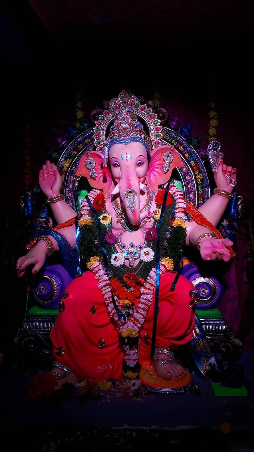 Vibrant Ganesha Idol Adorned with Jewels and Floral Garlands HD phone wallpaper