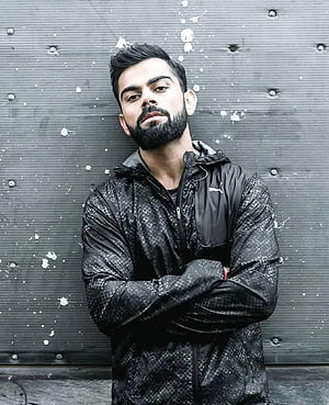 Virat Kohli in Black Puma Jacket with Arms Crossed Against Industrial Wall HD phone wallpaper