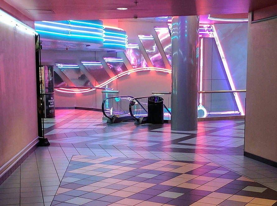Neon-lit interior corridor with geometric tile floor and glowing architectural accents HD wallpaper