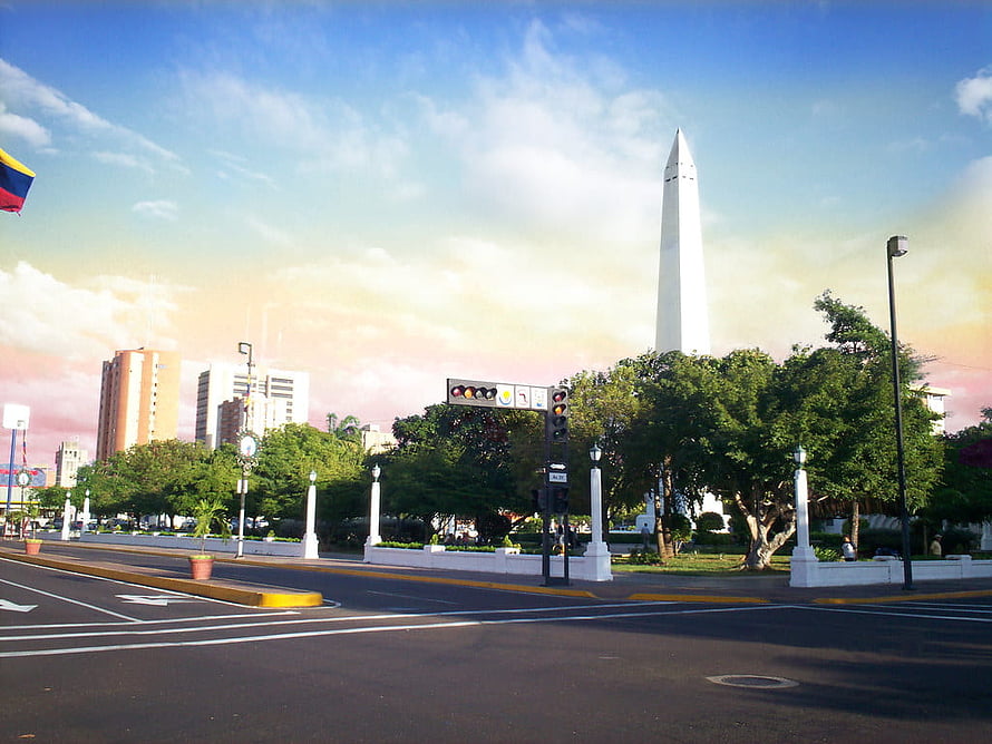Plaza República in Maracaibo with the Obelisco Monument and Venezuelan flag under a pastel sky HD wallpaper