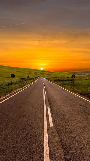Sunset Over Rolling Green Hills With A Winding Country Road HD phone wallpaper