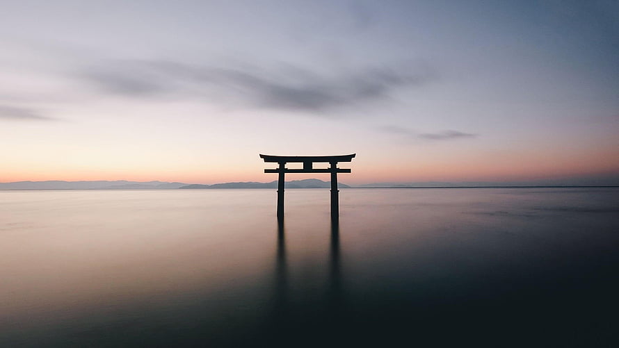 Serene Torii Gate Standing in Calm Water at Sunset HD wallpaper