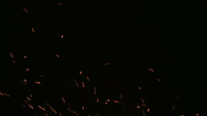 Glowing Orange Sparks Flying Against a Pitch Black Background HD wallpaper