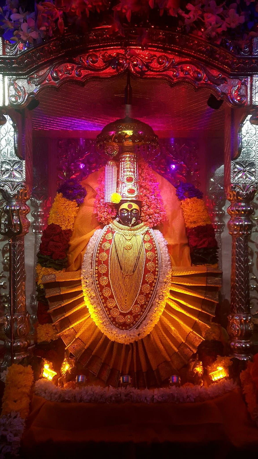 Ornate Hindu Deity Statue Adorned with Gold Jewelry and Flower Garlands in Temple Shrine HD phone wallpaper