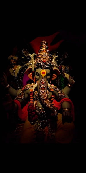 Ornate Ganesha Idol With Golden Crown And Red Garments In Dark Setting HD phone wallpaper