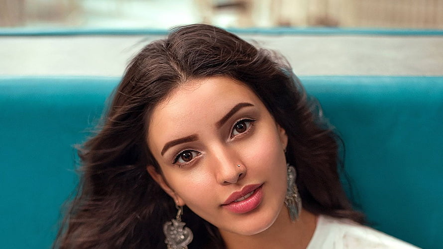 Tripti Dimri Portrait With Wavy Hair And Silver Earrings Against Teal Background HD wallpaper