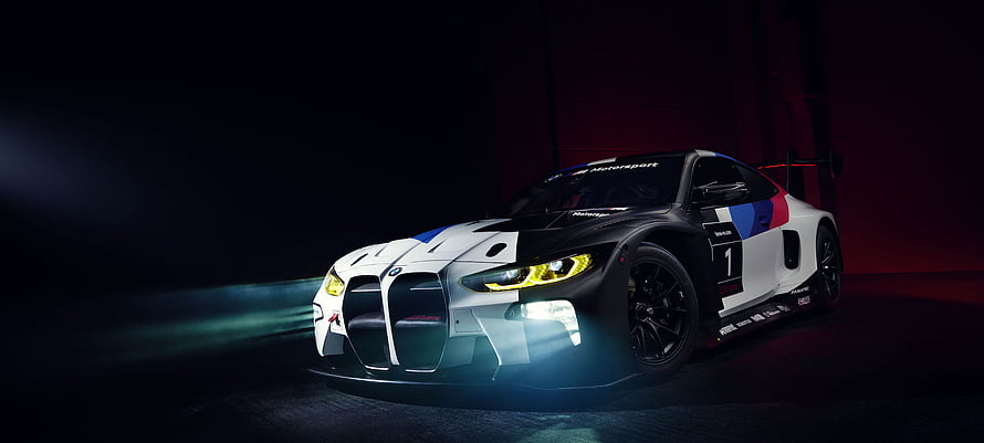 BMW M4 GT3 Race Car in Dark Studio Setting with Dramatic Lighting HD wallpaper